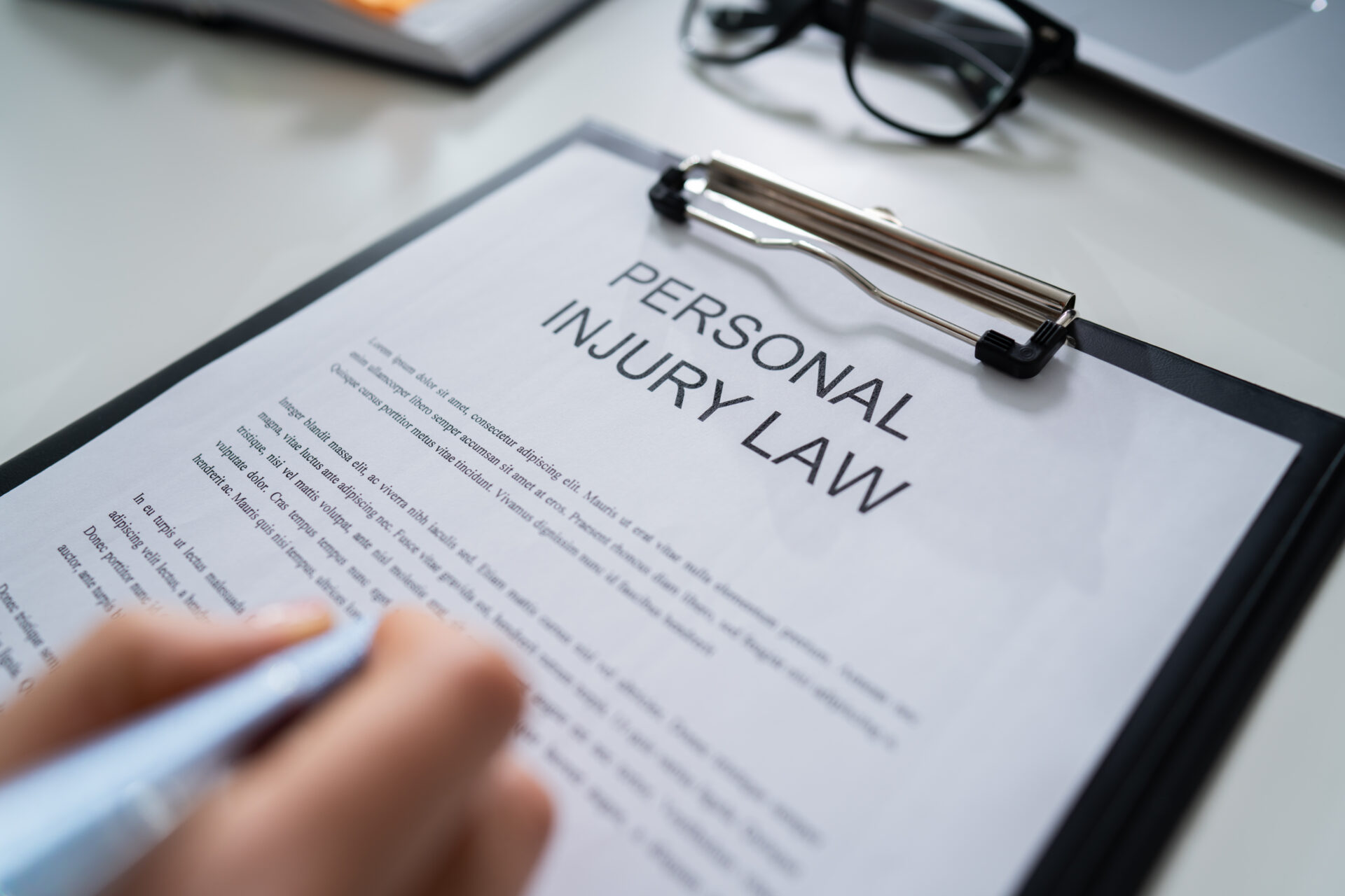 Signing a personal injury form and Elevated View Of Paper Of Personal Injury Law