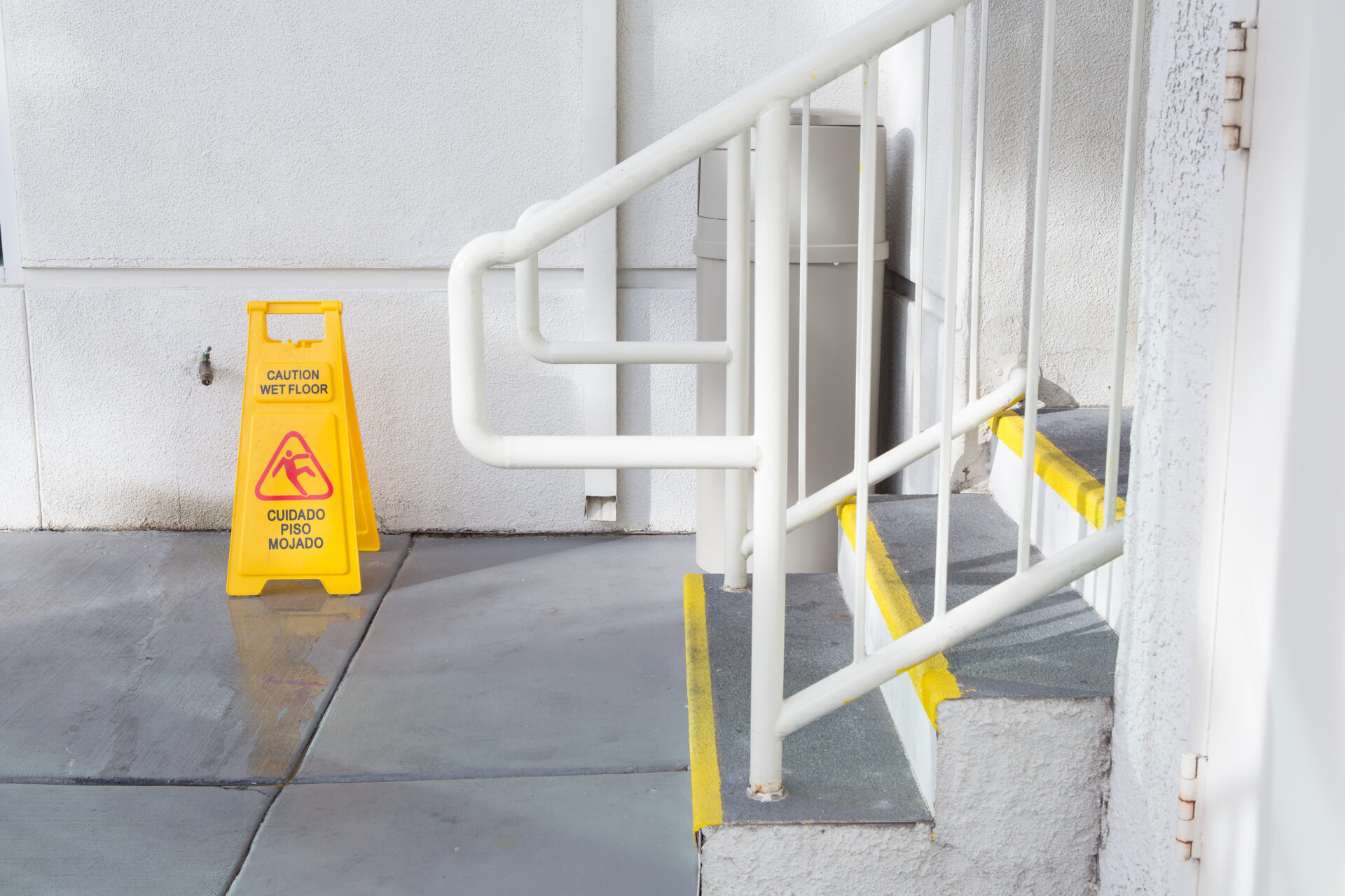 Yellow Wet Floor Sign Warning Of Slippery near staircase