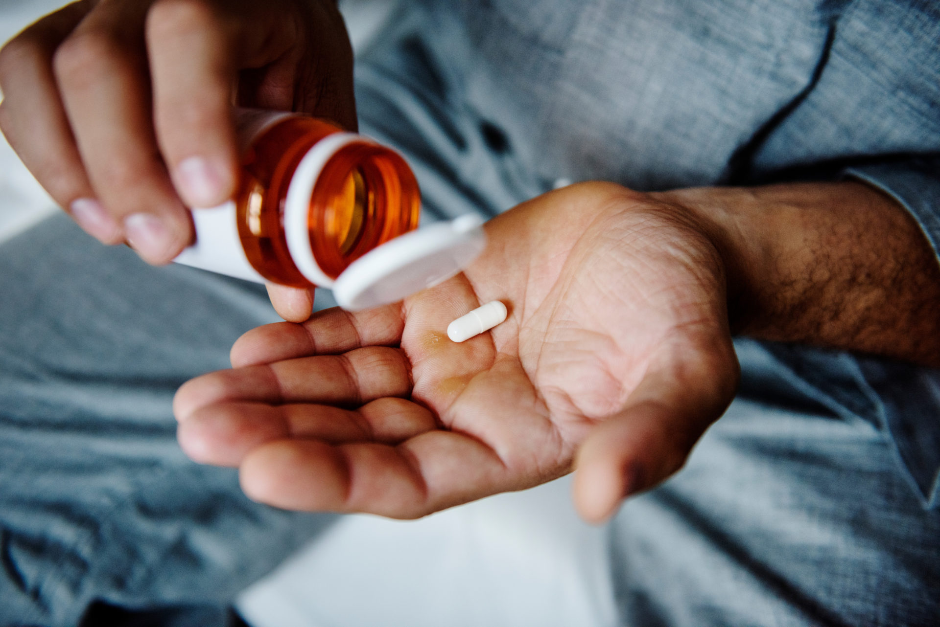 A patient taking pills from a pills bottle