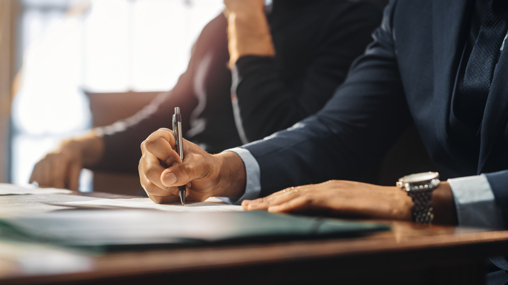 A lawyer in court wearing a suit and signing a document