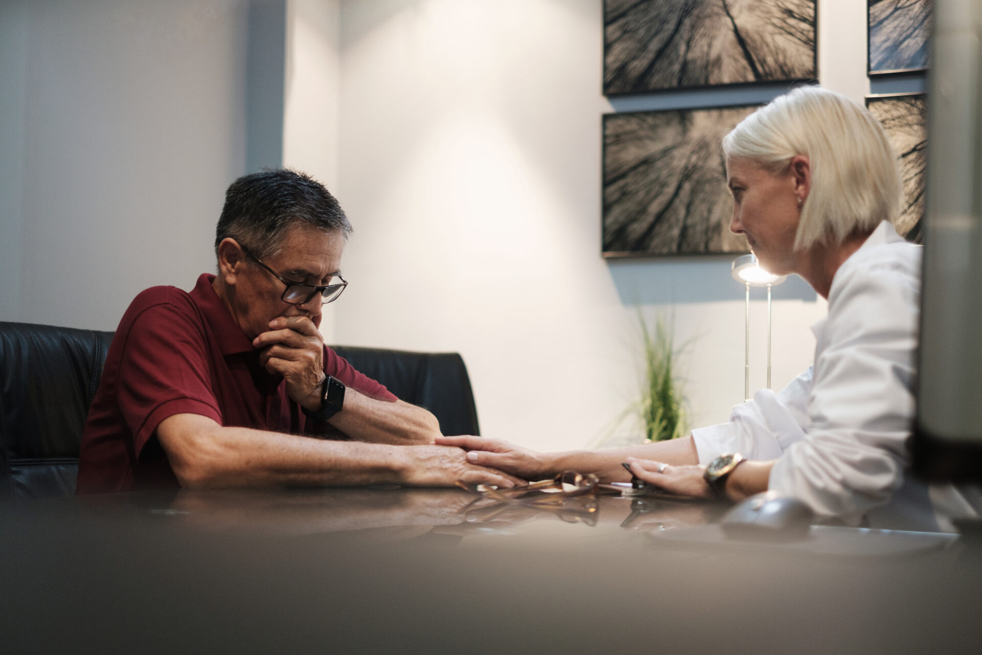 A doctor comforting a sad patient after a diagnosis in a hospital room table