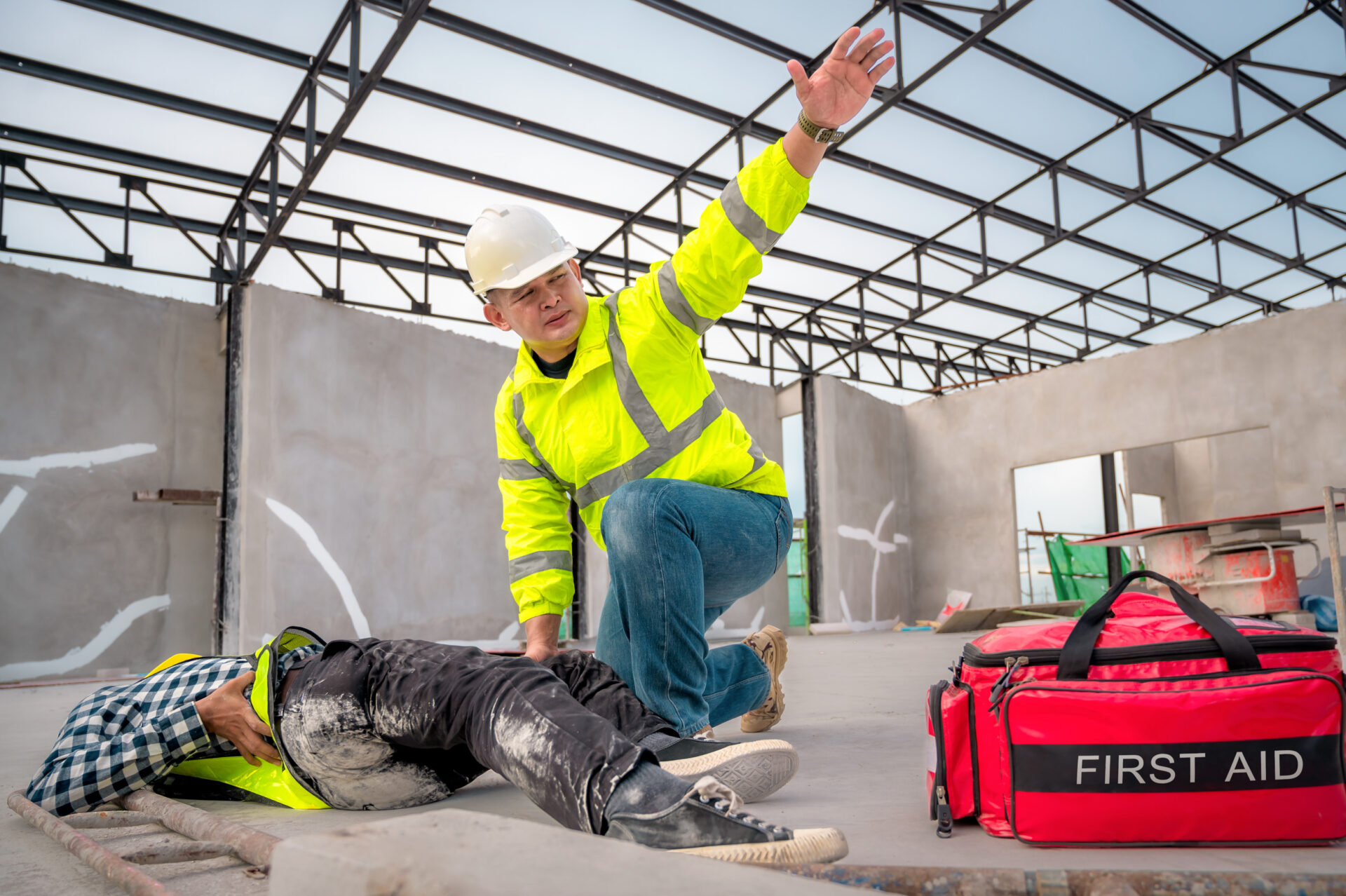 Construction accident, concerned constructor seeks immediate assistance for injured work partner lying on the floor.