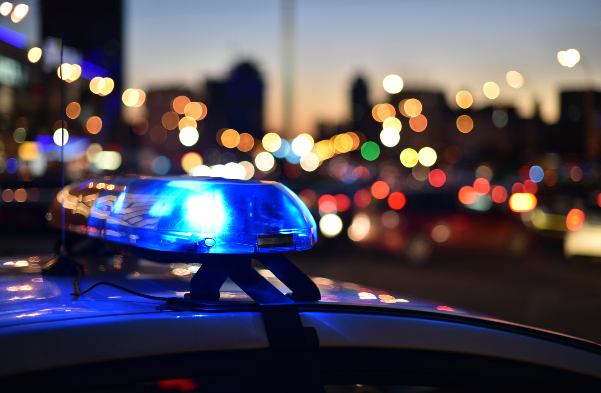 A vivid display of a police car's siren light illuminating the surroundings with vibrant flashes of red and blue.