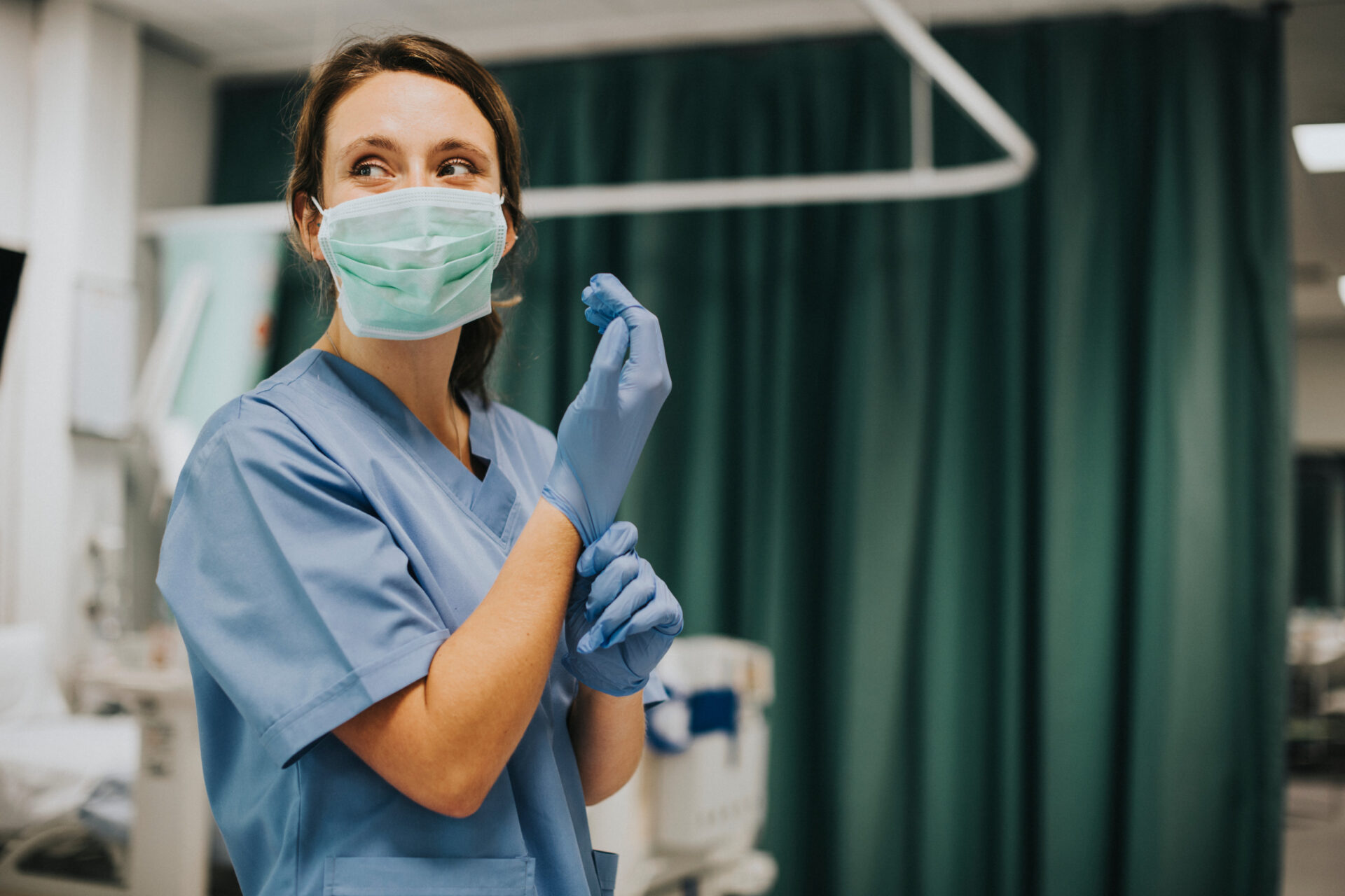 A nurse preparing for a procedure, skillfully donning a latex glove with focused attention to hygiene and patient safety.