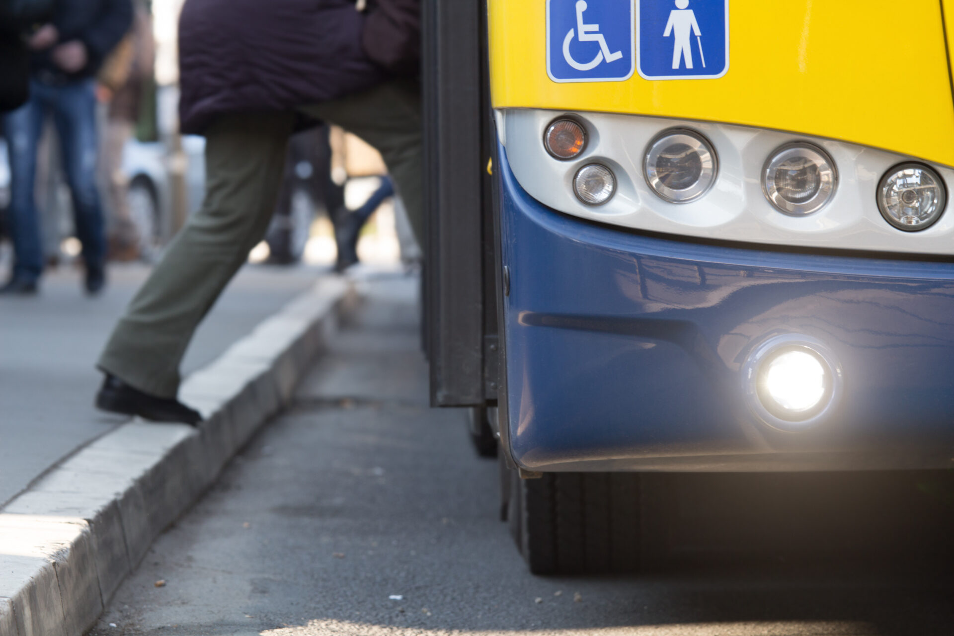 A person with a disability confidently boarding a bus displaying a handicap sign, exemplifying inclusive and accessible public transportation.