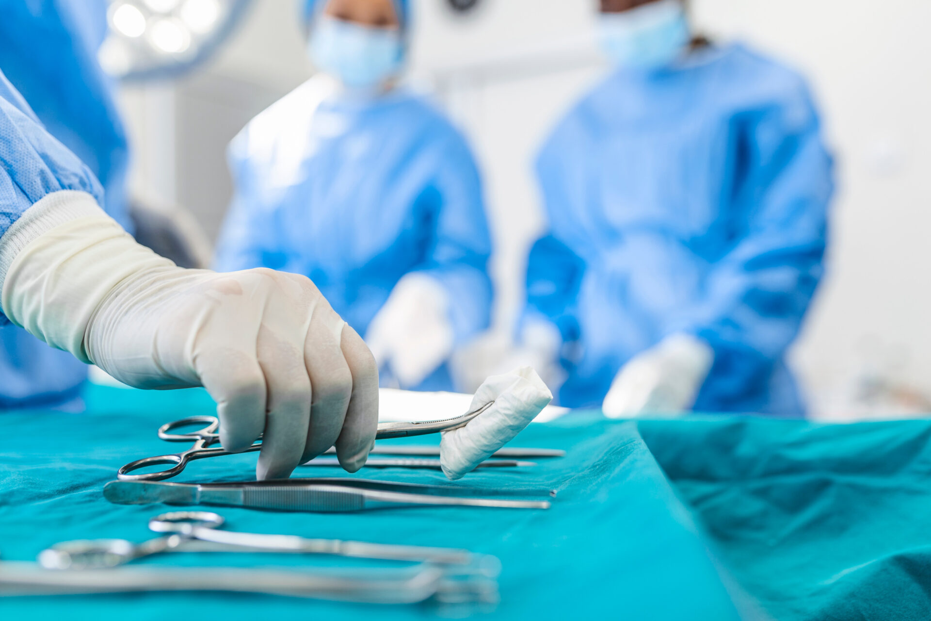 A skilled surgeon delicately grasping a tissue with surgical scissors, demonstrating precision and care in a surgical procedure.