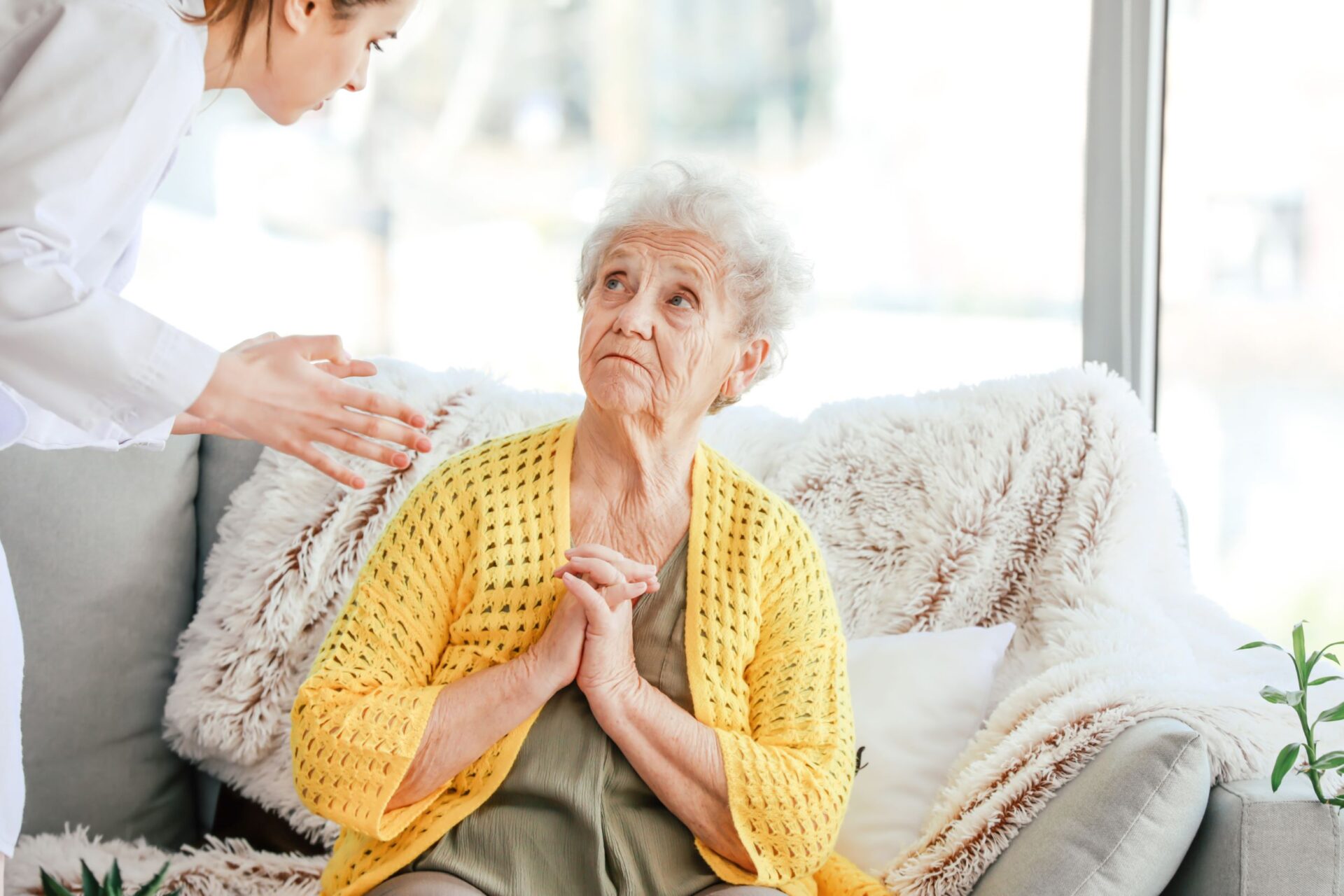 Nursing malpractice - a female nurse explaining to an elderly woman sitting down
